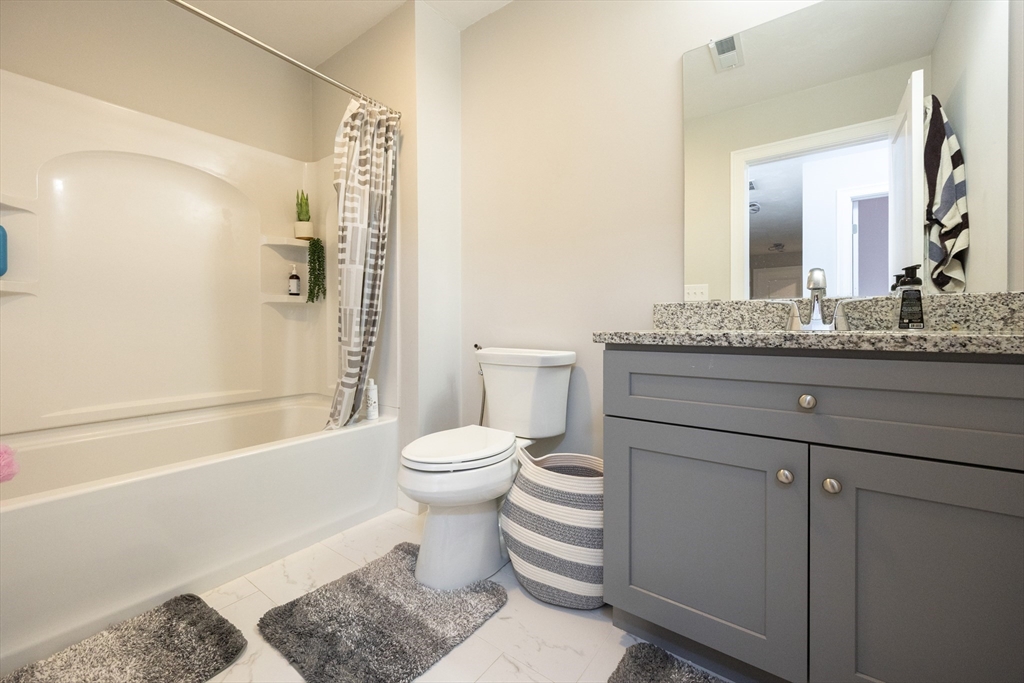 1 Clover Drive Bellingham, MA 02019 - Photo 28 of 34 a bathroom with a granite countertop toilet a sink and a bathtub