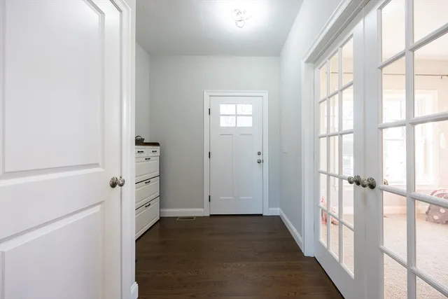 a view of a hallway with wooden floor and windows