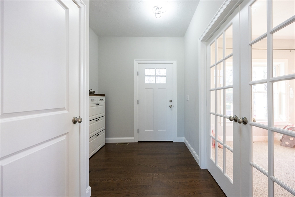 1 Clover Drive Bellingham, MA 02019 - Photo 4 of 34 a view of a hallway with wooden floor and windows