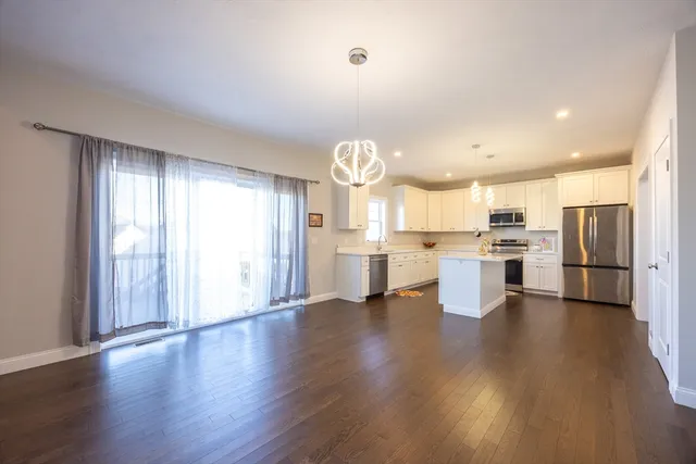 a open kitchen with cabinets wooden floor and stainless steel appliances