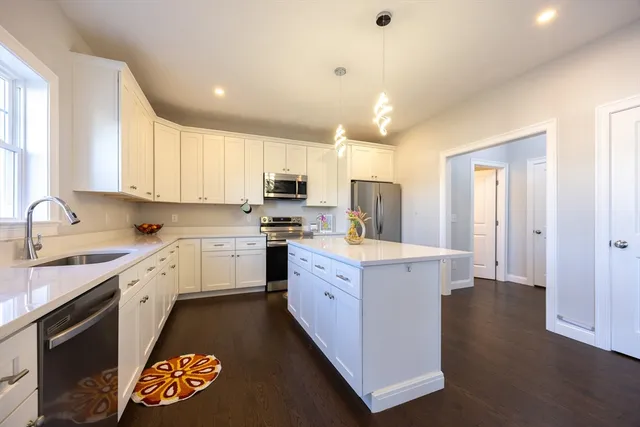 a kitchen with granite countertop white cabinets and white appliances