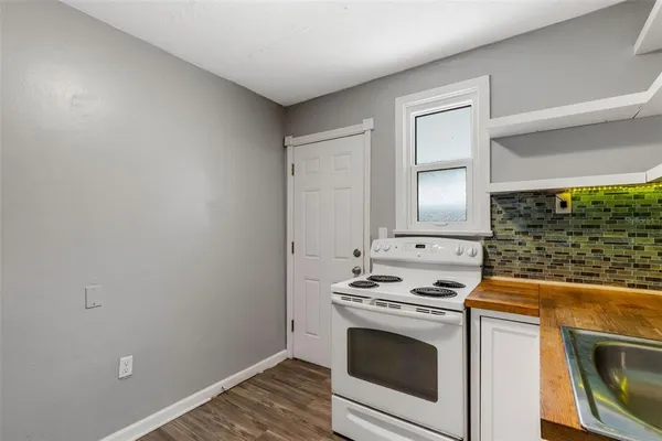 an empty room with wooden floor closet and fan