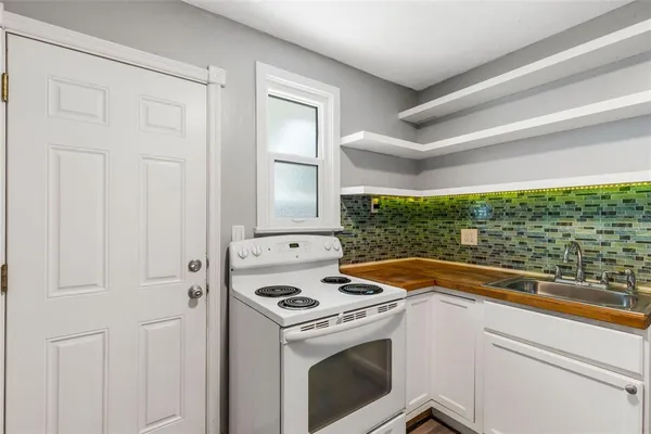 a white stove top oven sitting inside of a kitchen