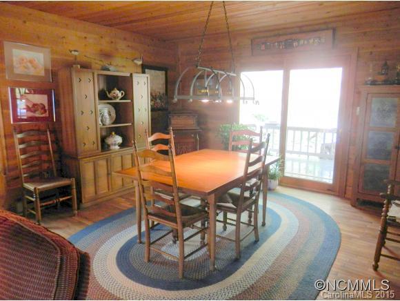 900 Mountain Cove Road Waynesville, NC 28786 - Photo 11 of 24 a dining room with furniture a chandelier and wooden floor