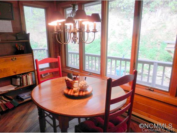 900 Mountain Cove Road Waynesville, NC 28786 - Photo 15 of 24 a view of a dining room with furniture a chandelier and wooden floor
