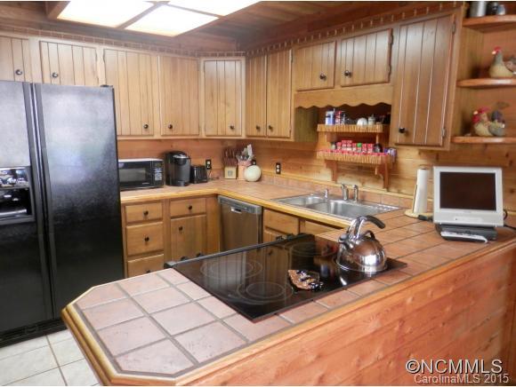 900 Mountain Cove Road Waynesville, NC 28786 - Photo 17 of 24 a kitchen with stainless steel appliances granite countertop a sink refrigerator and cabinets
