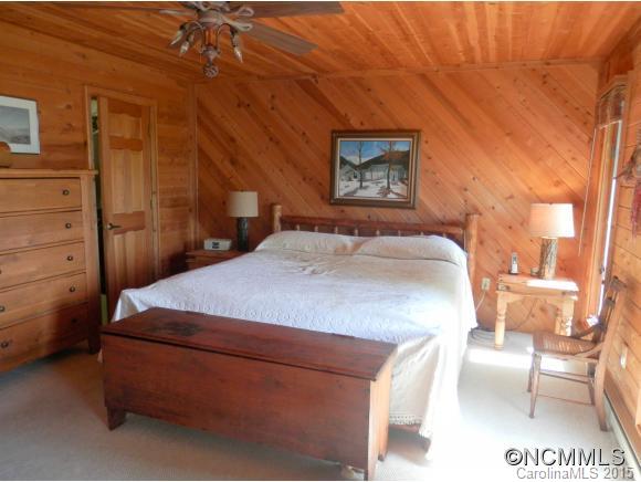 900 Mountain Cove Road Waynesville, NC 28786 - Photo 8 of 24 a bed sitting in a room next to a lamp