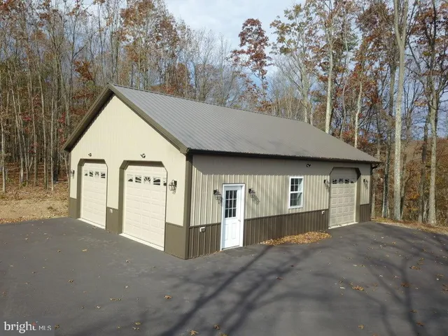 a view of a house with a yard and large tree