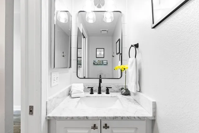 a bathroom with a granite countertop sink and a mirror