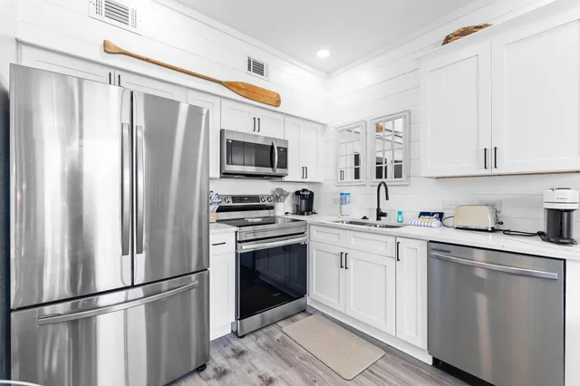 a kitchen with stainless steel appliances a refrigerator sink and microwave