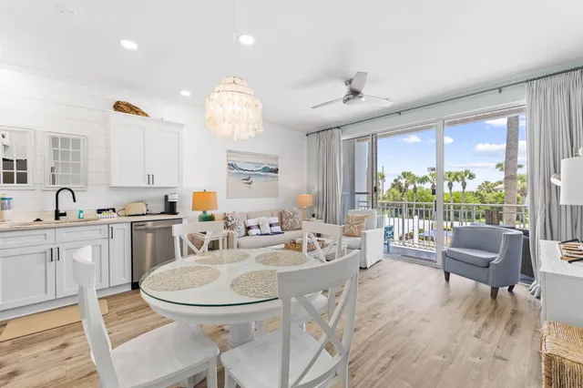 a kitchen with granite countertop a stove a sink a dining table and chairs