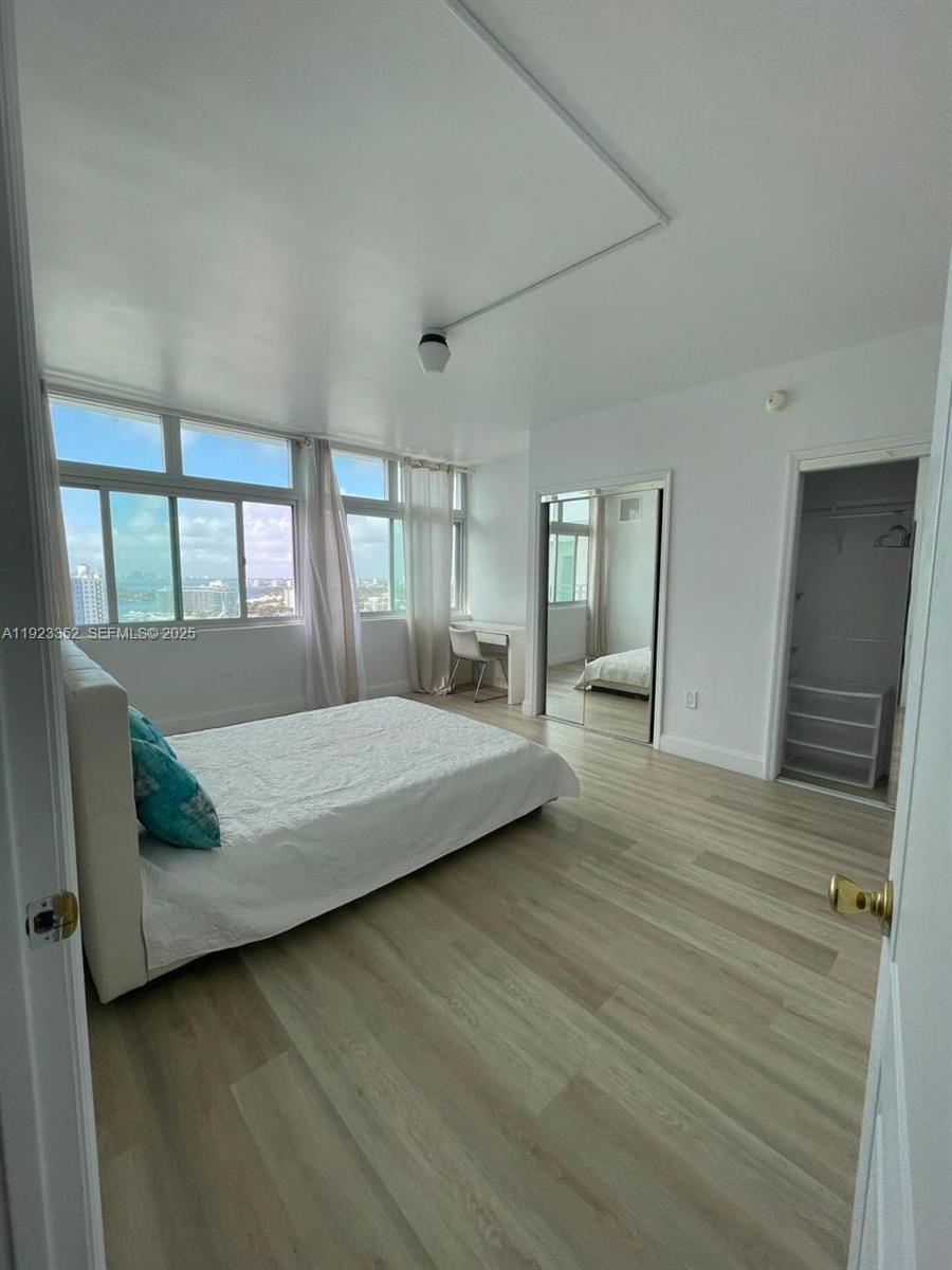 7135 Collins Avenue, Unit PH31 Miami Beach, FL 33141 - Photo 7 of 20 a bedroom with a bed wooden floor and large window