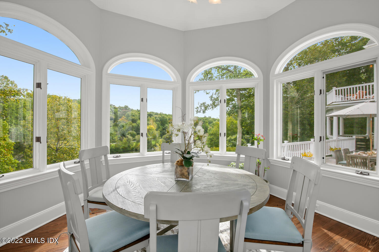 57 Partridge Hollow Road Greenwich, CT 06831 - Photo 33 of 102 a dining room with wooden floor a chandelier a glass table and chairs
