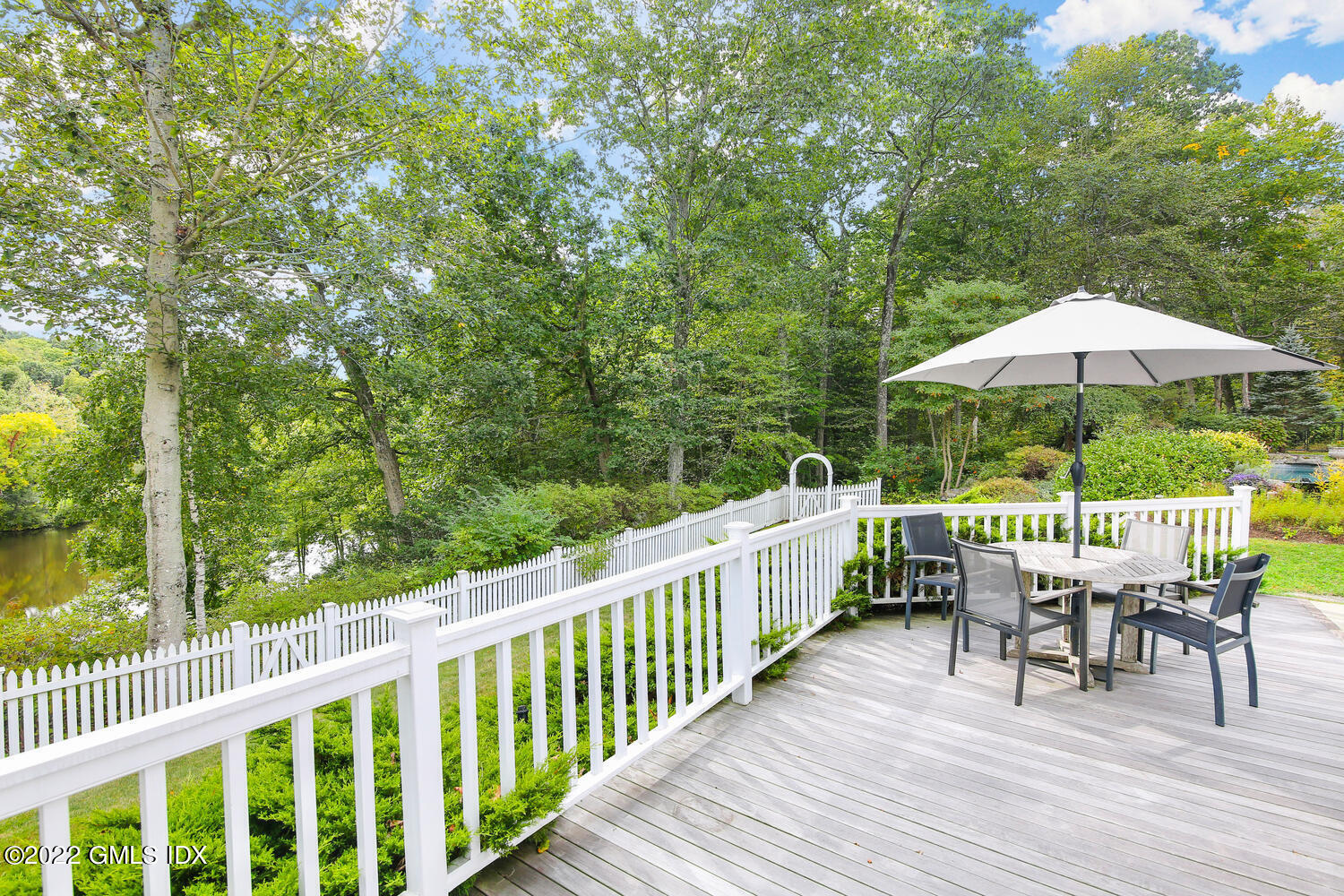 57 Partridge Hollow Road Greenwich, CT 06831 - Photo 60 of 102 a view of deck with furniture and barbeque oven in the backyard with wooden fence