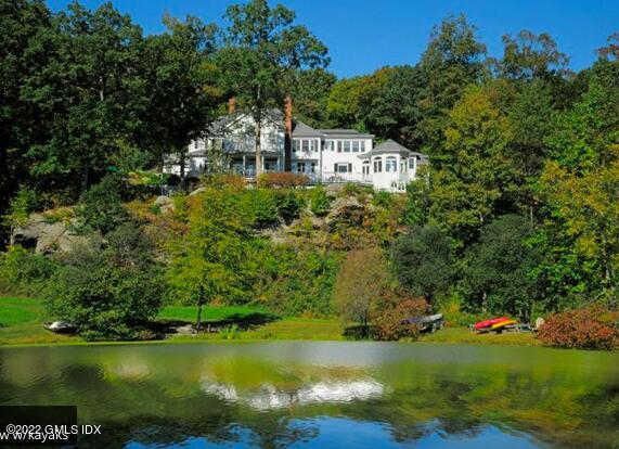 57 Partridge Hollow Road Greenwich, CT 06831 - Photo 79 of 102 a view of a house with a yard and a pond