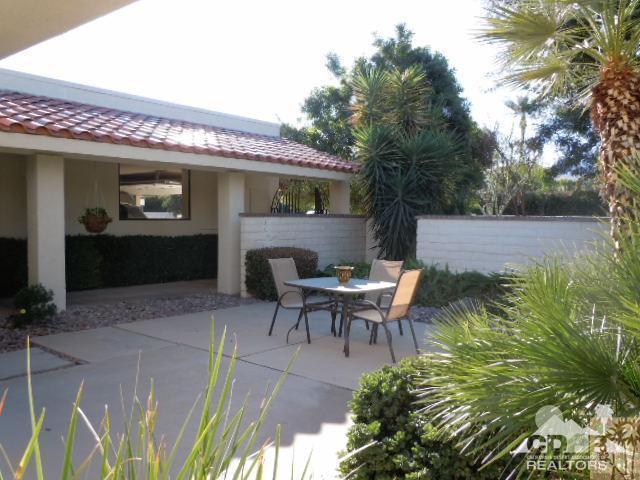 8 Duke Drive Rancho Mirage, CA 92270 - Photo 11 of 15 a view of a patio with table and chairs with wooden fence and plants