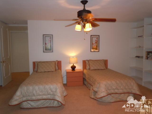 8 Duke Drive Rancho Mirage, CA 92270 - Photo 9 of 15 a bedroom with a bed and a chandelier