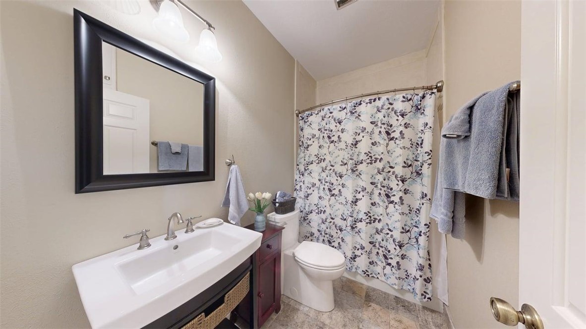 705 Walker Street Bryan, TX 77802 - Photo 20 of 46 a bathroom with a sink toilet and mirror