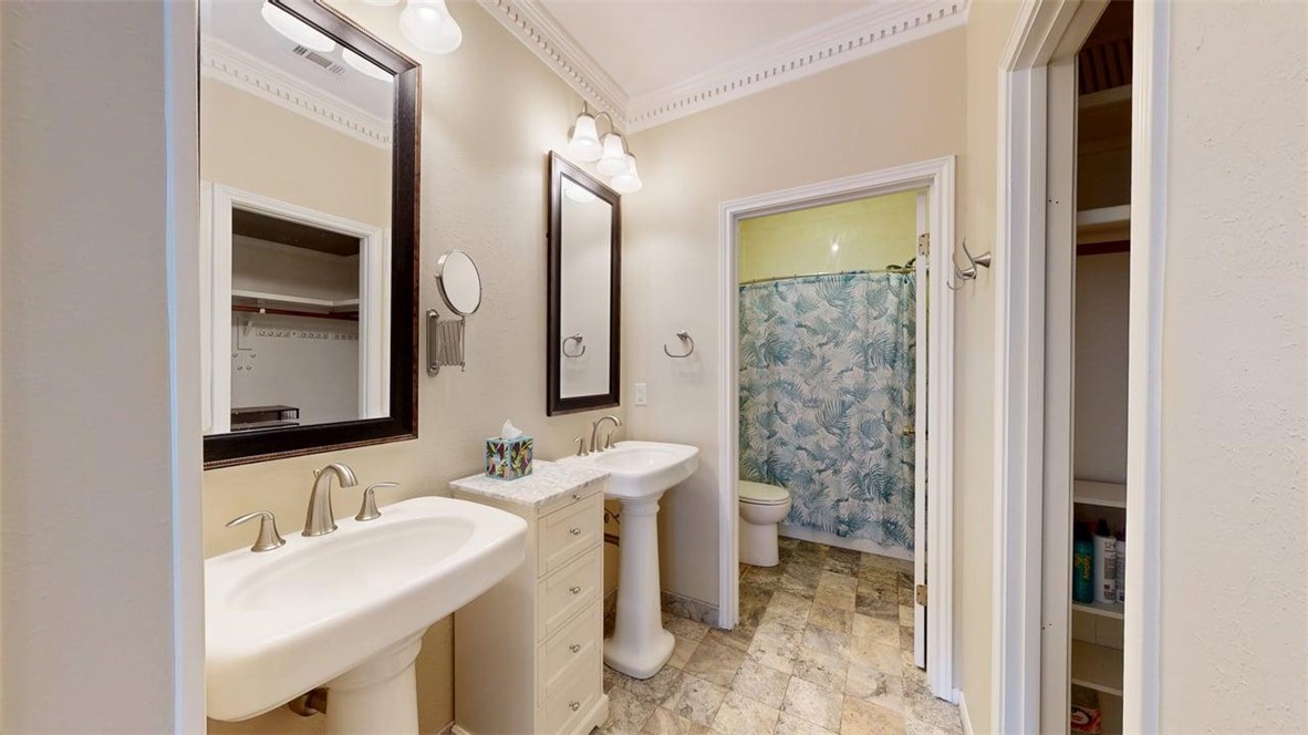 705 Walker Street Bryan, TX 77802 - Photo 25 of 46 a bathroom with a granite countertop sink a toilet and a mirror