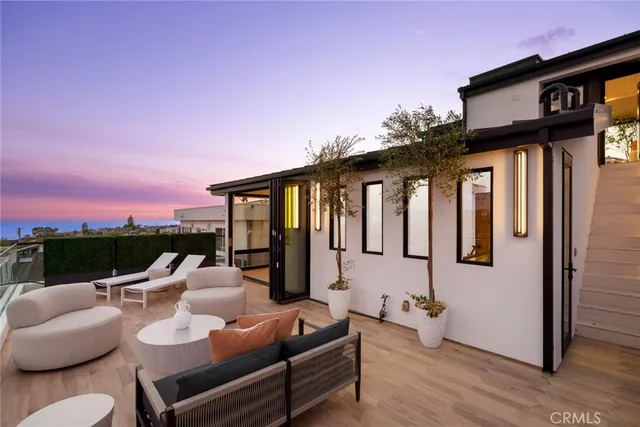 a view of a patio with couches table and chairs with wooden floor and fence
