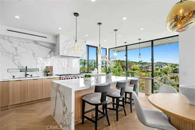 a large living room with stainless steel appliances kitchen island granite countertop furniture a rug a fireplace and a large window