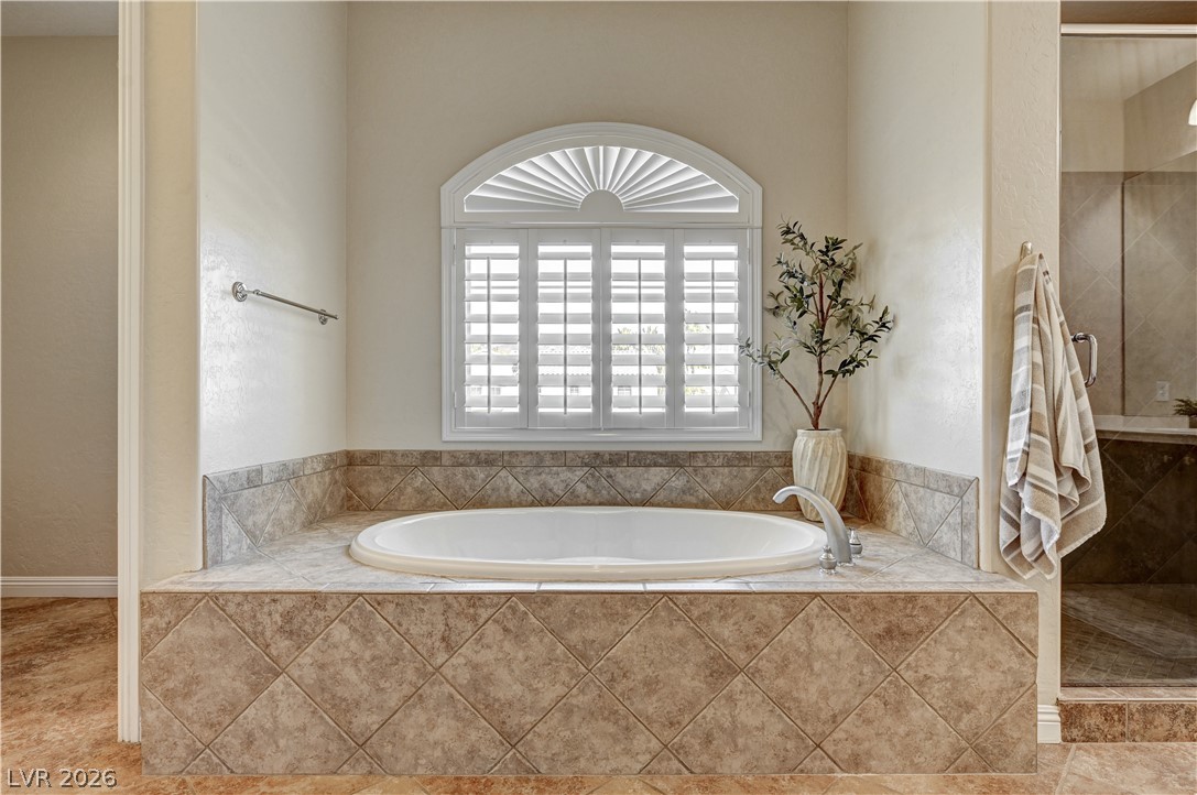 2793 Rosenhearty Drive Henderson, NV 89044 - Photo 42 of 77 An inviting soaking tub nestled beneath a window with elegant plantation shutters.