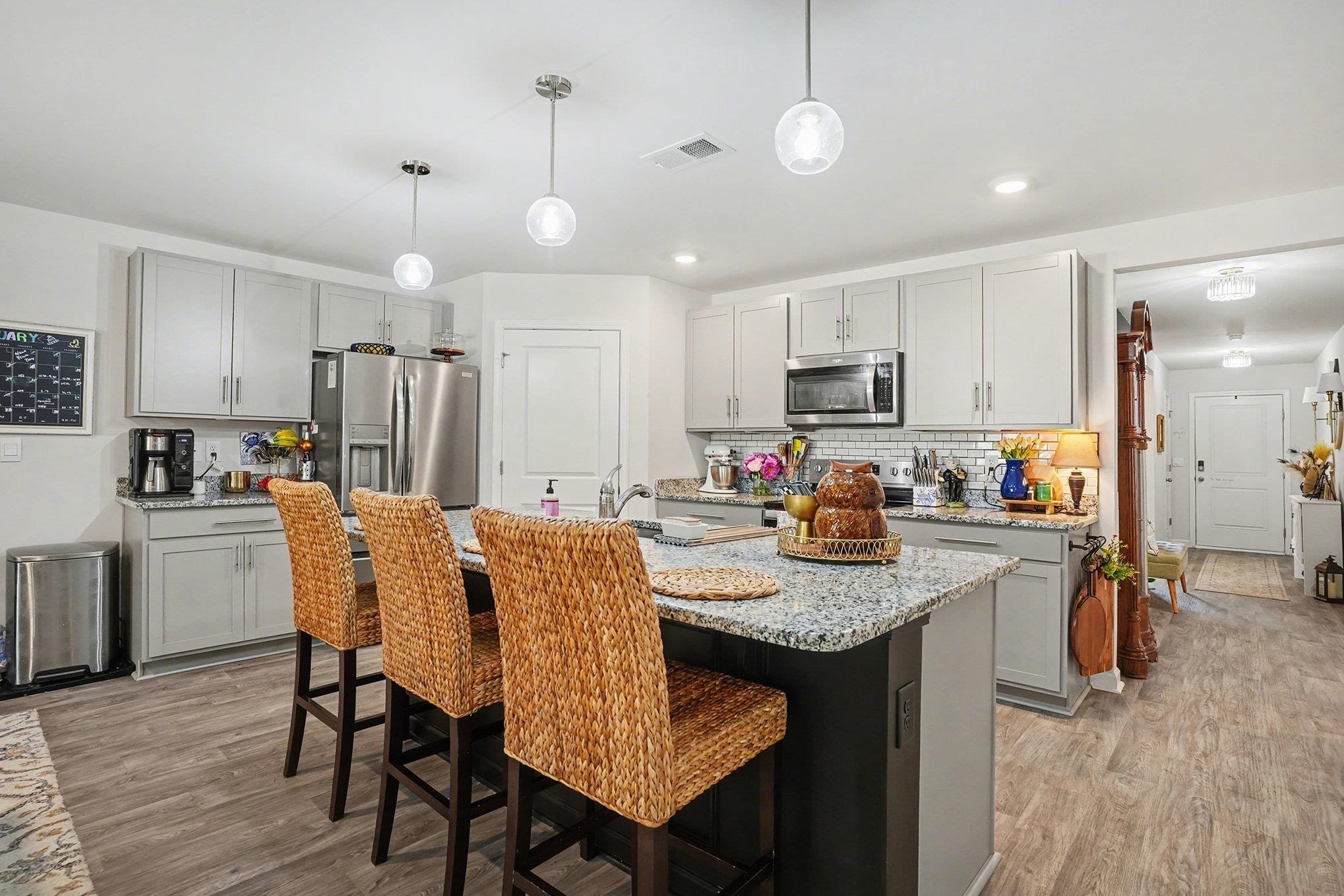 172 Seasons Trace Loop Longs, SC 29568 - Photo 12 of 37 Kitchen with hanging light fixtures, light stone counters, light wood-style floors, a breakfast bar area, and gray cabinetry