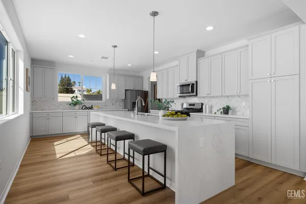 a kitchen with kitchen island white cabinets and stainless steel appliances