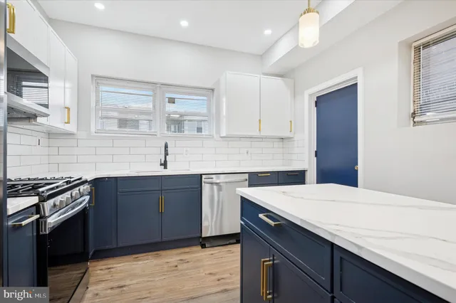 a kitchen with a sink dishwasher a stove and a microwave oven with cabinets