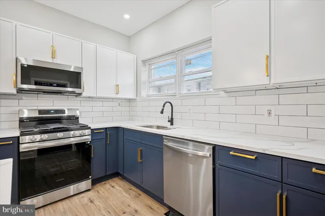 a kitchen with stainless steel appliances granite countertop a sink dishwasher a stove and a microwave oven with cabinets