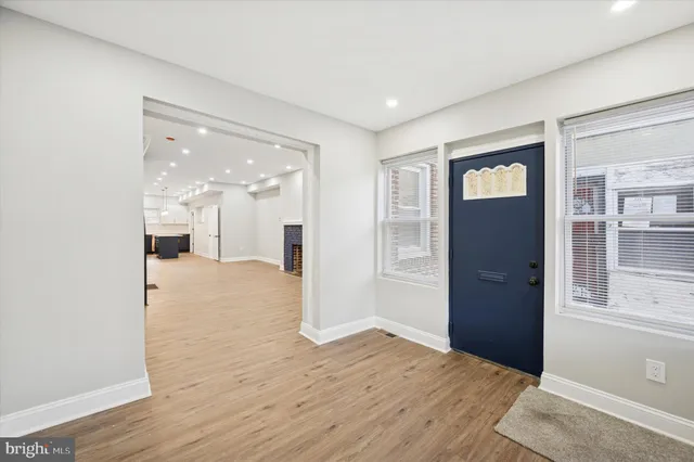 a view of a big room with wooden floor and windows