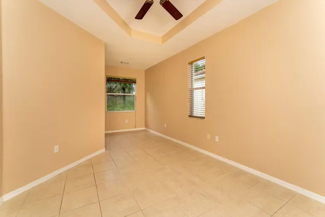 an empty room with windows and ceiling fan