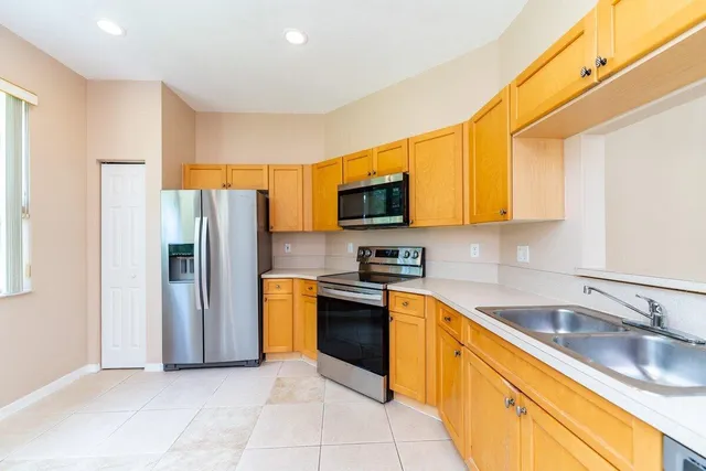 a kitchen with stainless steel appliances granite countertop a refrigerator and a sink