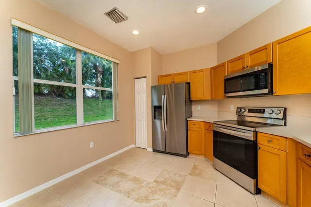 a kitchen with stainless steel appliances granite countertop a refrigerator a stove top oven a sink and dishwasher