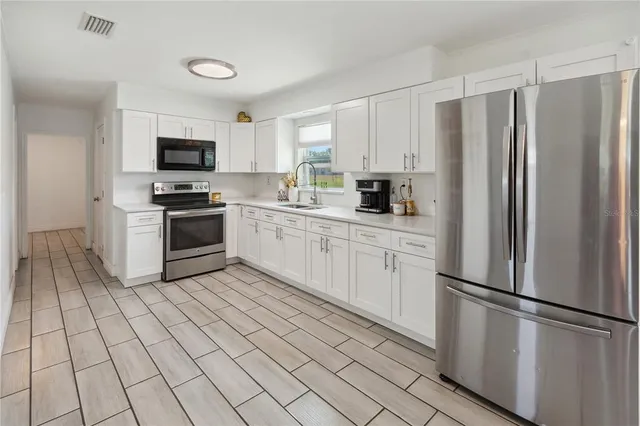 a kitchen with stainless steel appliances granite countertop a refrigerator sink and stove