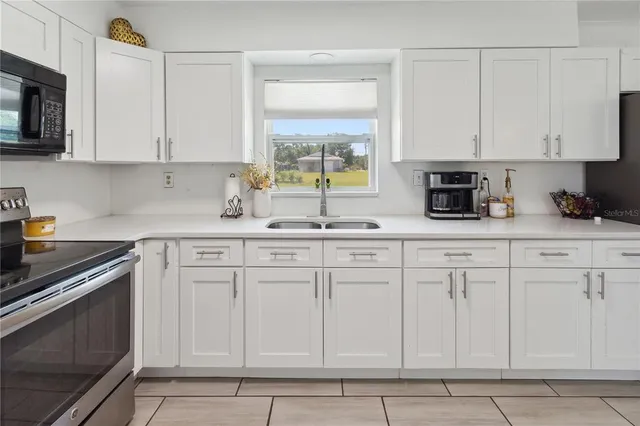 a kitchen with white cabinets and white appliances