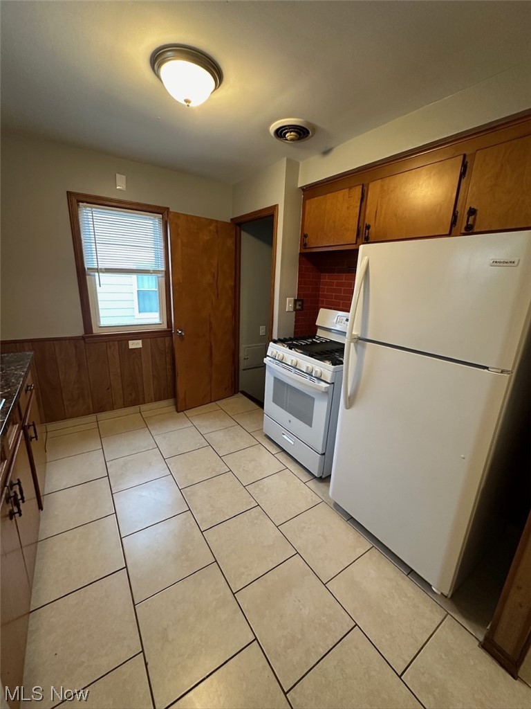 4994 North Barton Road Cleveland, OH 44124 - Photo 8 of 28 Kitchen featuring light tile floors, white appliances, and tasteful backsplash