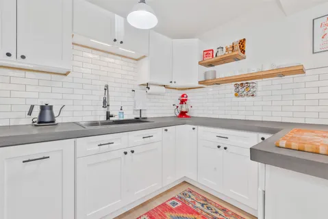 a kitchen with white cabinets and sink