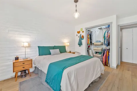 a bedroom with a bed a dresser and a book shelf