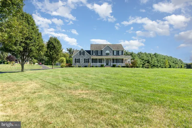 a front view of a house with a yard and potted plants