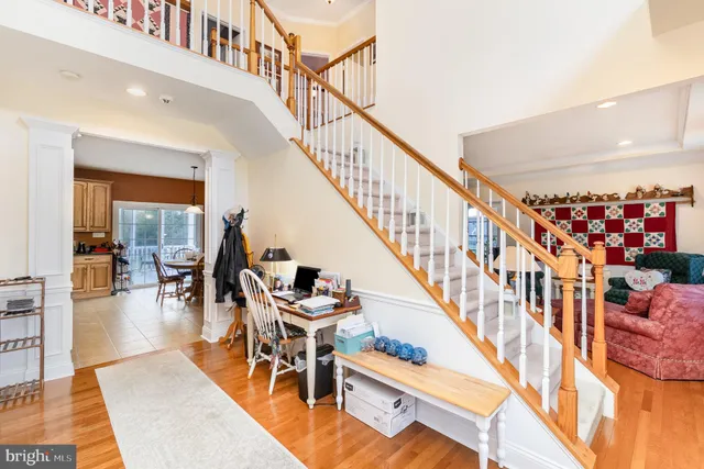 a dining room with wooden floor a chandelier a wooden table and chairs