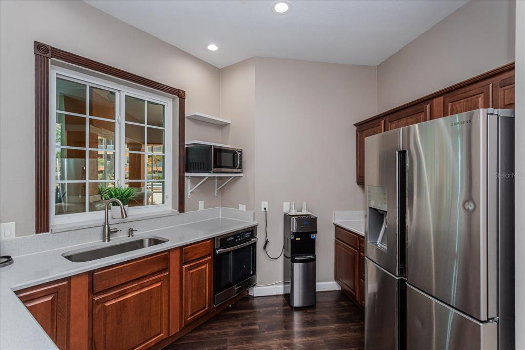 5455 Vineland Road, Unit 3214 Orlando, FL 32811 - Photo 20 of 25 a kitchen with stainless steel appliances granite countertop a refrigerator a sink a stove and a wooden floors