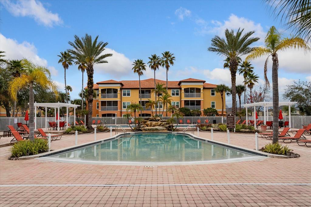 5455 Vineland Road, Unit 3214 Orlando, FL 32811 - Photo 22 of 25 a view of swimming pool with outdoor seating and house in the background