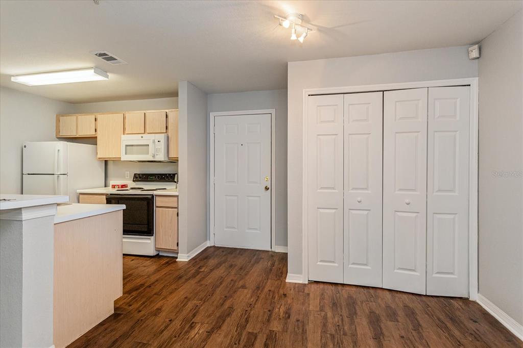 5455 Vineland Road, Unit 3214 Orlando, FL 32811 - Photo 4 of 25 a kitchen with white cabinets and wooden floor