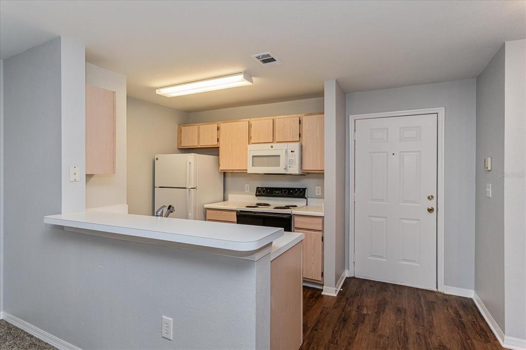 5455 Vineland Road, Unit 3214 Orlando, FL 32811 - Photo 5 of 25 a kitchen with granite countertop a stove a sink and a refrigerator