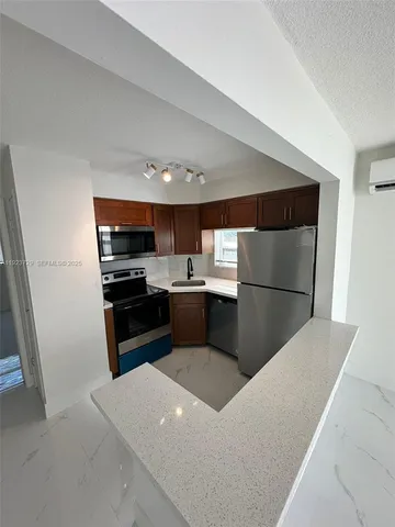 a kitchen with stainless steel appliances a refrigerator and a stove top oven