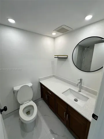 a bathroom with a toilet a sink and mirror