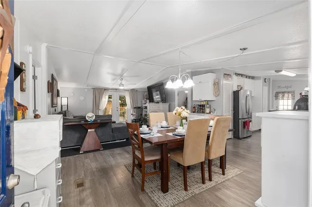 a view of a dining room with furniture a chandelier and wooden floor