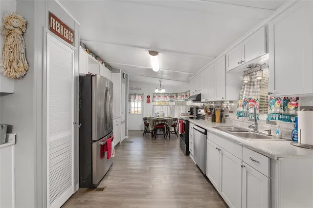 a kitchen with stainless steel appliances a stove a sink cabinets and a counter top space