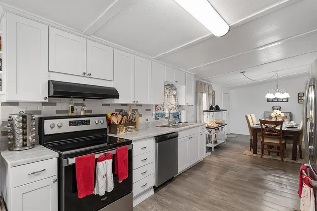 a kitchen with granite countertop white cabinets and white appliances